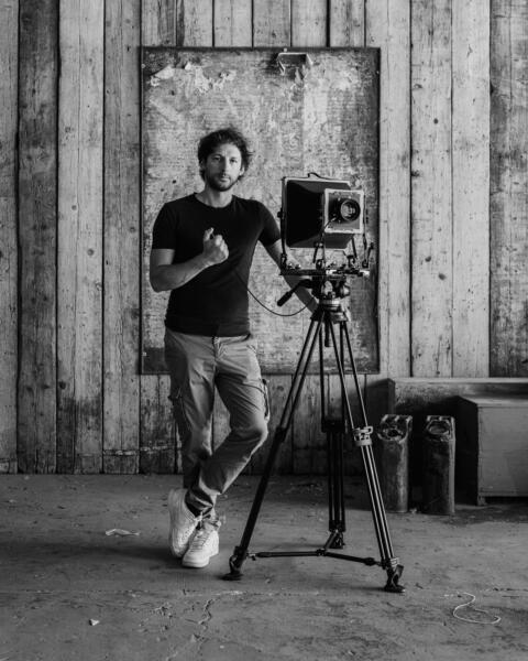 Antonio Lacchini accanto a una fotocamera di grande formato su treppiede