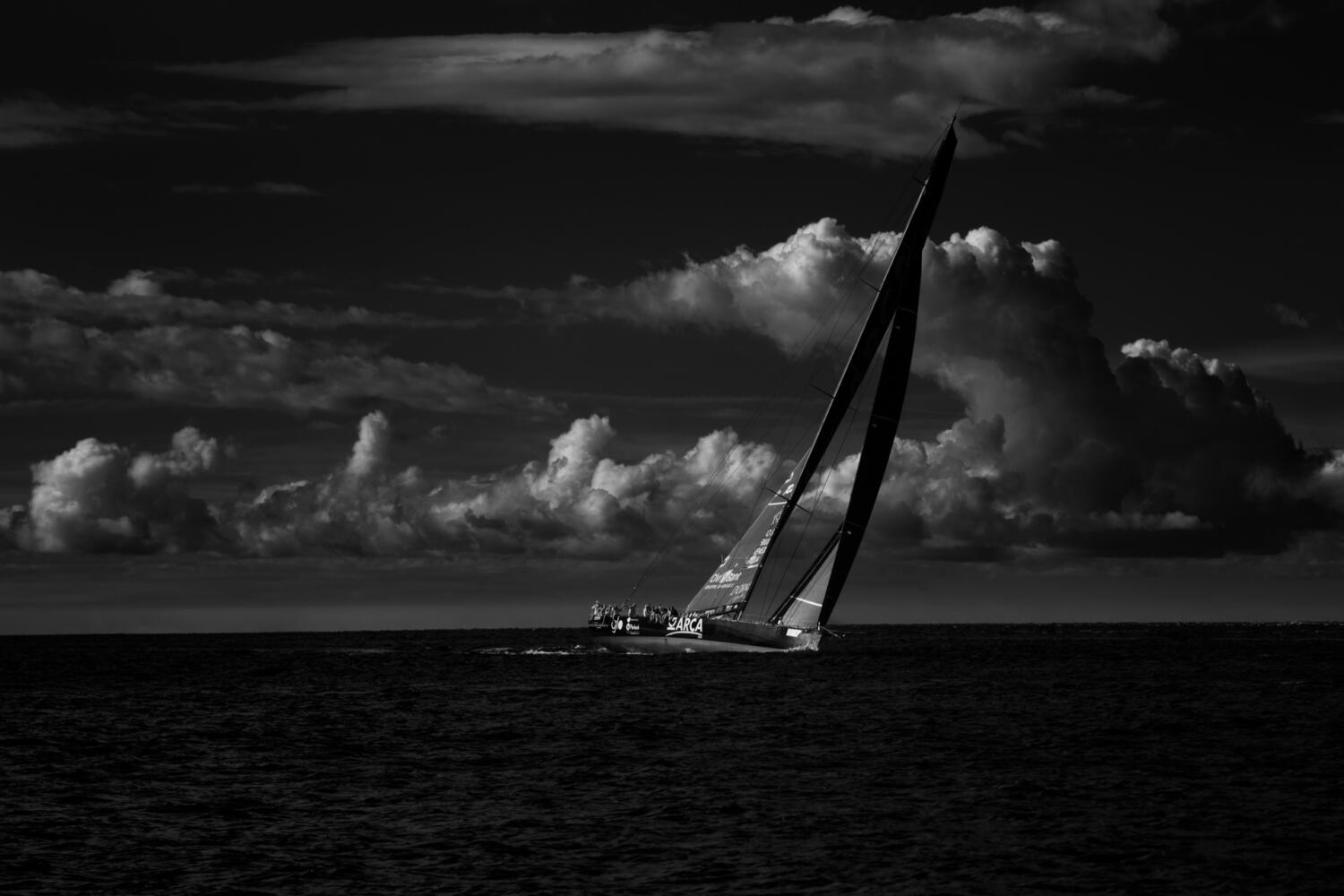 Barca da regata inclinata sotto i cumuli, mare scuro, Barcolana 2026
