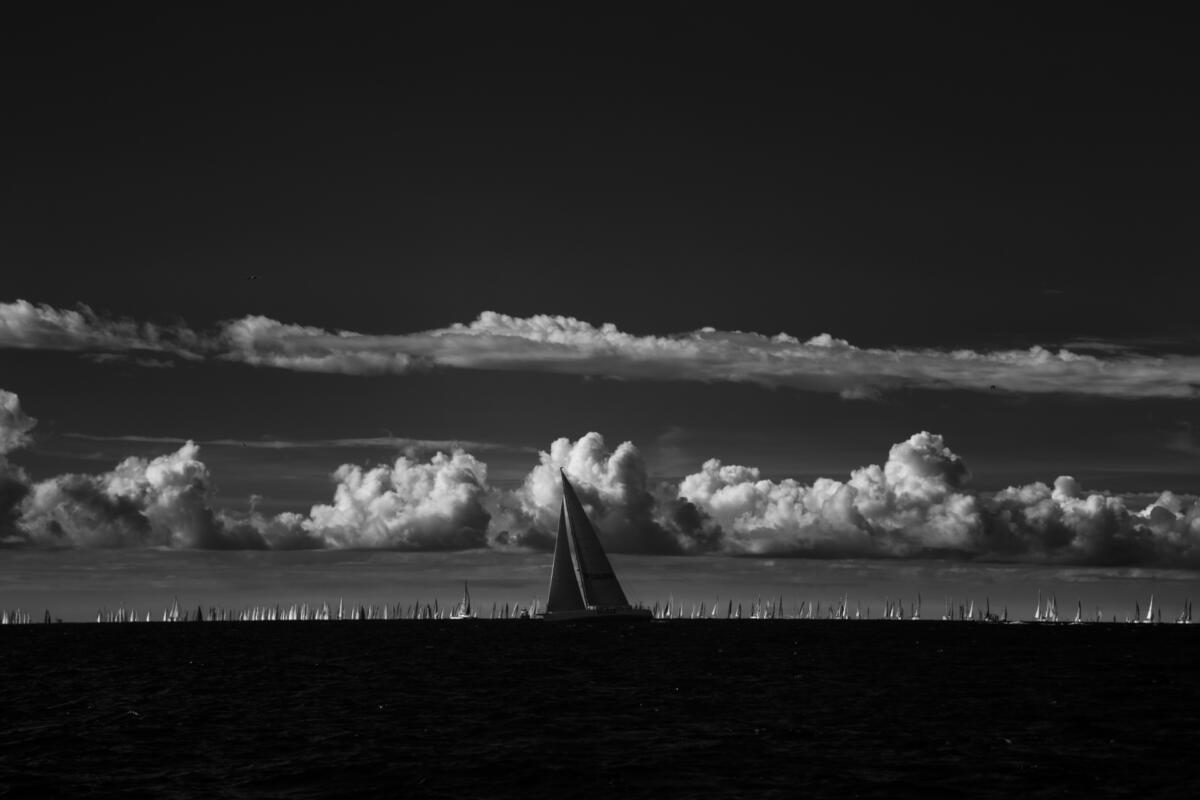 Una barca davanti alla flotta lontana e a una linea di cumuli, Barcolana 2026