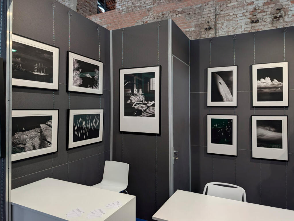 Stand di Opera Viva al Salone Nautico di Venezia, con stampe in bianco e nero alle pareti